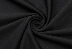 Macro detail of the black knitted fabric texture and elegant pleated material on the dress