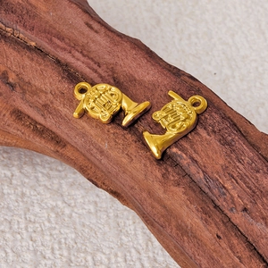 Golden 304 stainless steel French horn pendants on dark wood for DIY necklaces