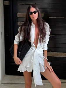 Detail of white long sleeve shirt dress with deep V-neck and waist tie design