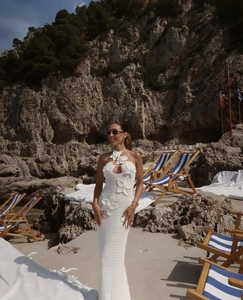 Detail of 3D floral embellishments and knit texture on white halter neck maxi dress