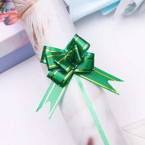Detail of dark green gift pull bow with gold stripes on a lavender box surface