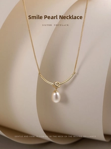 Detail of s925 silver gold-plated necklace featuring a knot tube and freshwater pearl