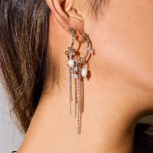 Luxurious stainless steel tassel earrings with pearls and gold accents on a model