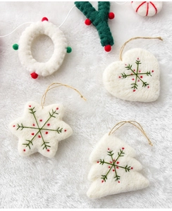Detailed view of handmade wool felt Christmas ornaments with embroidery and wooden string