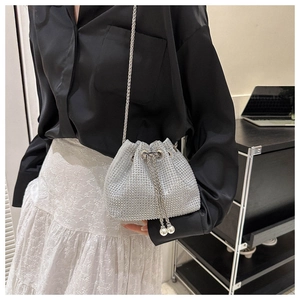 Close-up of silver rhinestone bucket bag with pearl tassel and metal chain strap