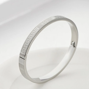 Detail of silver stainless steel cuff featuring Jesus engraving and Greek key pattern