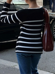 Tenue de rue avec tricot à rayures noires et blanches et sac à bandoulière en cuir rouge