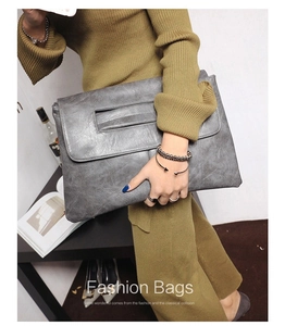 Close-up of large grey PU leather envelope clutch with litchi texture and foldover flap