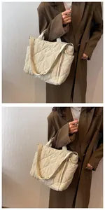 Detailed view of the large beige quilted tote bag with side zipper and crossbody strap