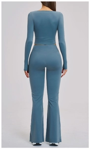 Back view of gray blue yoga set featuring long sleeve crop top and flared leggings