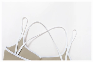 Detail of khaki sports bra with white contrast piping and crisscross back straps