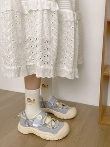 Gros plan de chaussettes beiges avec broderie chien et chaussures en toile à carreaux