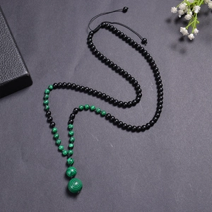 Macro view of woven bead necklace with malachite pattern stones and adjustable cord