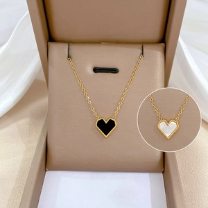 Minimalist gold titanium necklace with heart shell pendant in a cream jewelry box