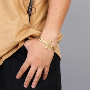 Close-up of a gold-plated cross chain bracelet worn on a wrist for a stylish look