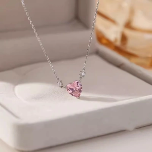 Pink heart pendant necklace with silver chain displayed in a white jewelry box