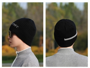 Detail der schwarzen Rippstrick-Beanie mit weißer FUMY-Stickerei im Seitenprofil