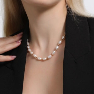 Elegant natural freshwater pearl necklace with gold spacer beads on model in black suit