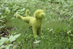 Detailed view of artificial grass flocked puppy ornament in lifelike urinating pose