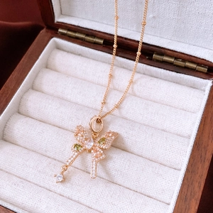 Detail of vintage gold bow necklace with green zircons on velvet jewelry display