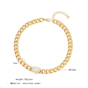 Close-up of gold cuban chain necklace with green diamond heart pendant and size markings
