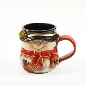 Christmas snowman ceramic coffee mug with festive red scarf and brown body on white background