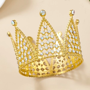 Macro shot of gold rhinestone crown cake topper with sparkling crystals on beige background