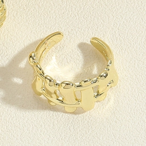 Detailed close-up of a golden wave-shaped adjustable ring with a polished fluid design