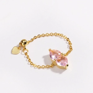 Detail of adjustable gold chain ring featuring dual pink heart crystals and heart charm