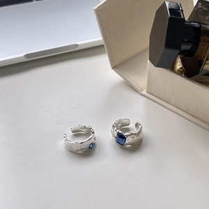 Close-up of irregular textured silver ring featuring a deep blue rectangle zircon gemstone