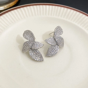 Gros plan détaillé des boucles d'oreilles feuilles en argent serties de cristaux