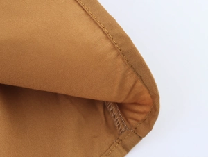Close-up of brown fabric texture and high-quality stitching on sleeveless dress