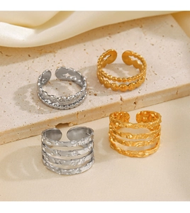 Detail view of gold and silver hammered stackable rings on stone with satin background