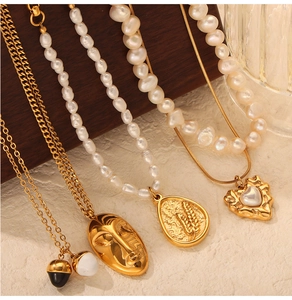Detail of vintage heart and face relief pendants with pearls and golden chains