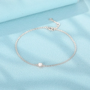 Nahaufnahme des S925 Sterlingsilber-Armbands mit weißem Opal auf blauem Hintergrund