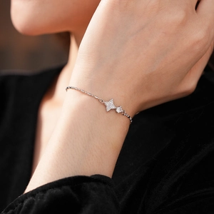 Détail d'un bracelet étoile en argent avec zircons sur le poignet d'une femme