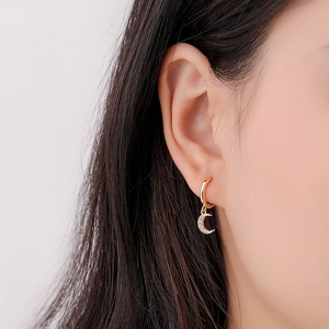 Close-up of S925 silver golden moon drop earrings with sparkling crystals on earlobe