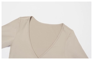 Detail view of the V-neckline and high-elastic knit texture of the yoga top in beige