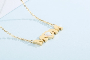 Detailed view of golden MOM necklace featuring a heart-shaped opal and polished chain