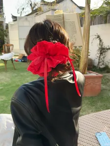 Macro shot of red heavy lace scrunchie with long ribbons on a model's ponytail
