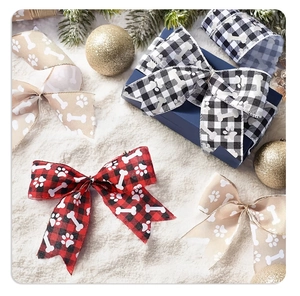 Macro view of Christmas plaid ribbons with dog paw prints for festive gift wrapping