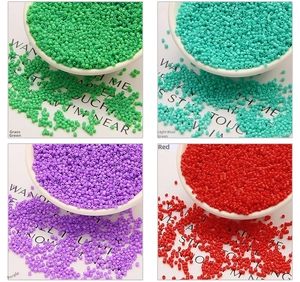 Macro detail of 2mm glass beads in green, purple, and red for DIY jewelry making