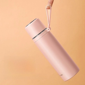 Pink stainless steel thermal flask with flexible silicone handle on orange background