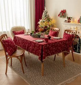 Detailed view of red Christmas tablecloth and cushion covers with festive fringe and patterns