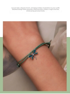 Detail of green dragonfly charm bracelet with enamel wings and adjustable woven cord