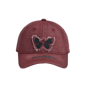 Detail of butterfly embroidery and Free Flight text on a burgundy denim baseball cap