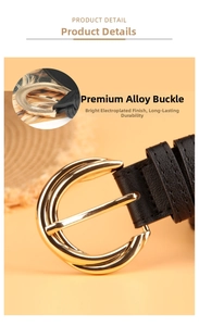 Detail of a thin black leather belt with a polished gold alloy round pin buckle