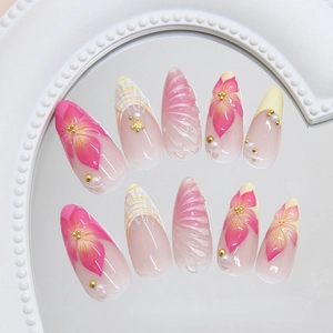Pink and white stiletto press-on nails with 3D flowers, pearls and seashell textures