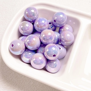 Macro shot of 14mm iridescent purple beads with pearl luster on white ceramic tray