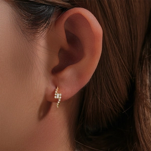Macro shot of gold S925 silver lightning hoop earrings with sparkling white zircons